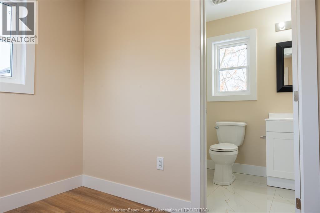 A bathroom with a toilet and a window.