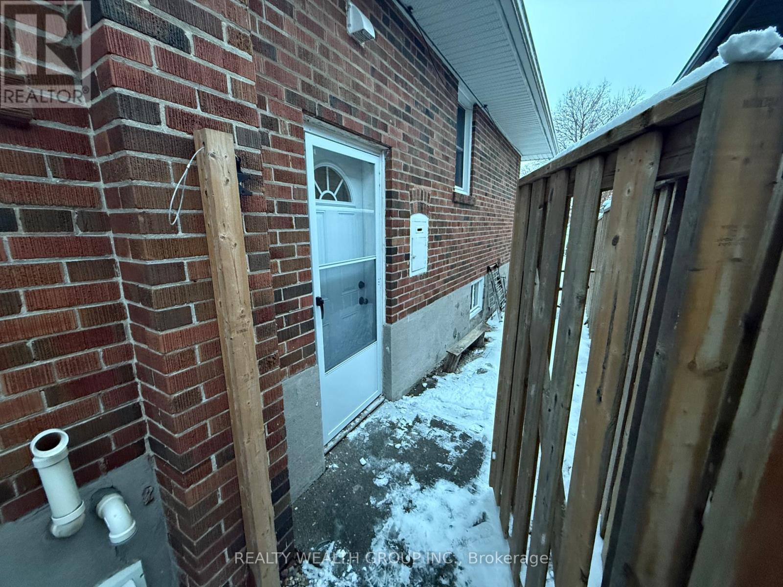 A house with a white door and a brick wall.
