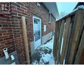 A house with a white door and a brick wall.