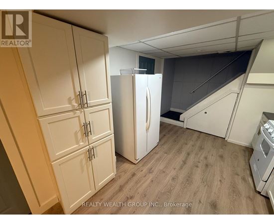 A kitchen with a refrigerator and cabinets.