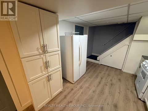 A kitchen with a refrigerator and cabinets.