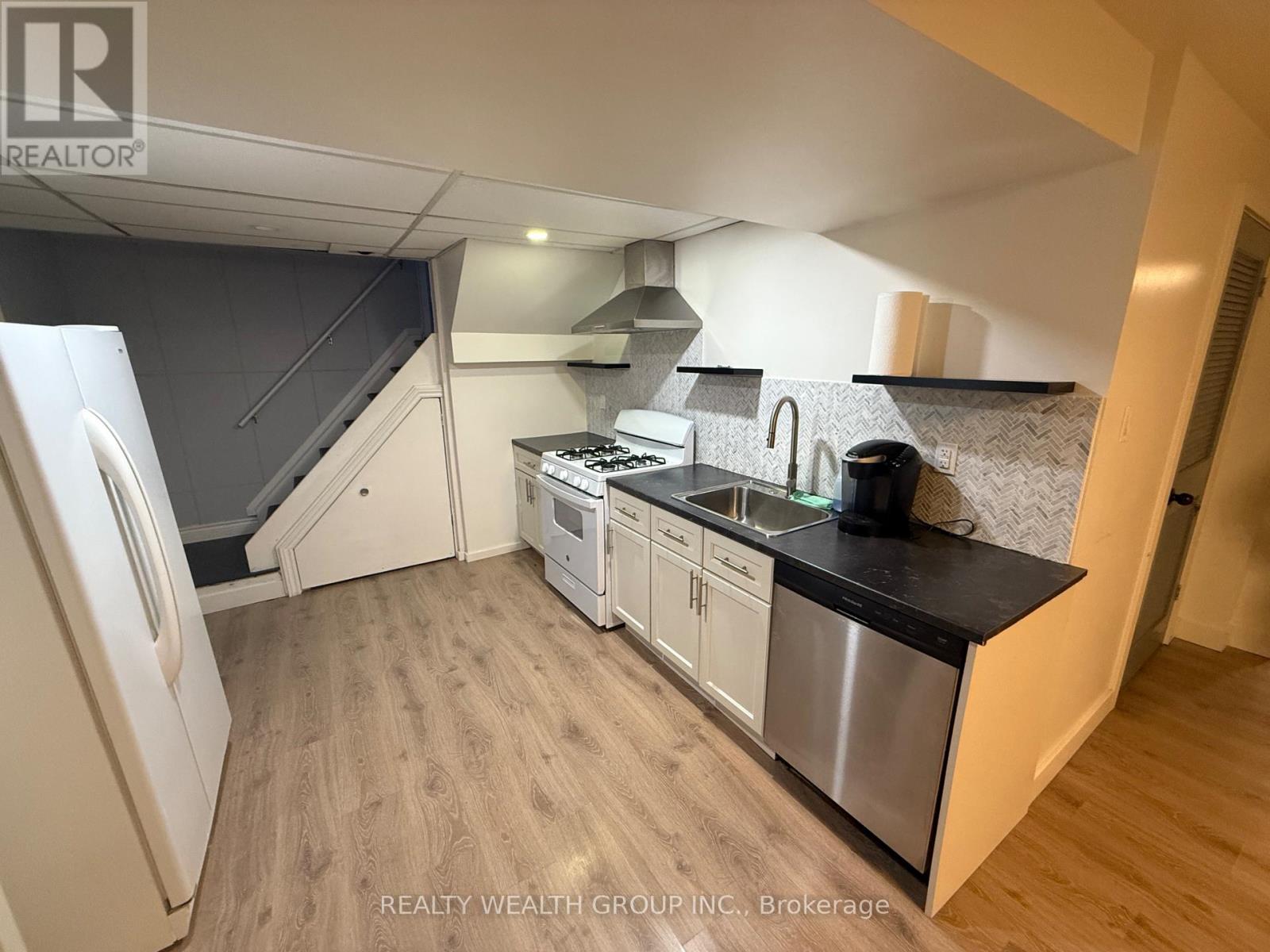 A kitchen with a stainless steel sink and refrigerator.