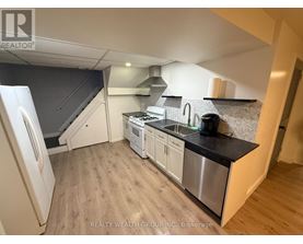 A kitchen with a stainless steel sink and refrigerator.