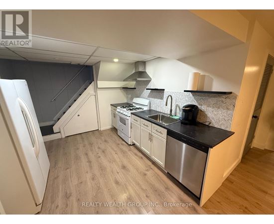 A kitchen with a stainless steel sink and refrigerator.