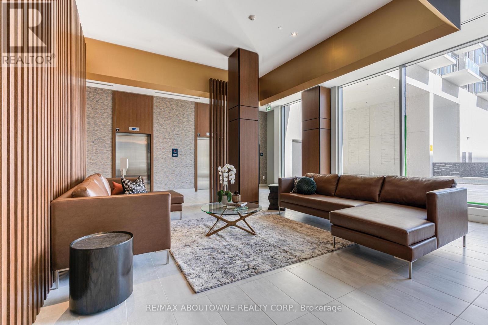 A modern living room with a brown sofa and a glass table.