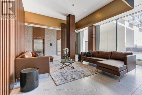 A modern living room with a brown sofa and a glass table.