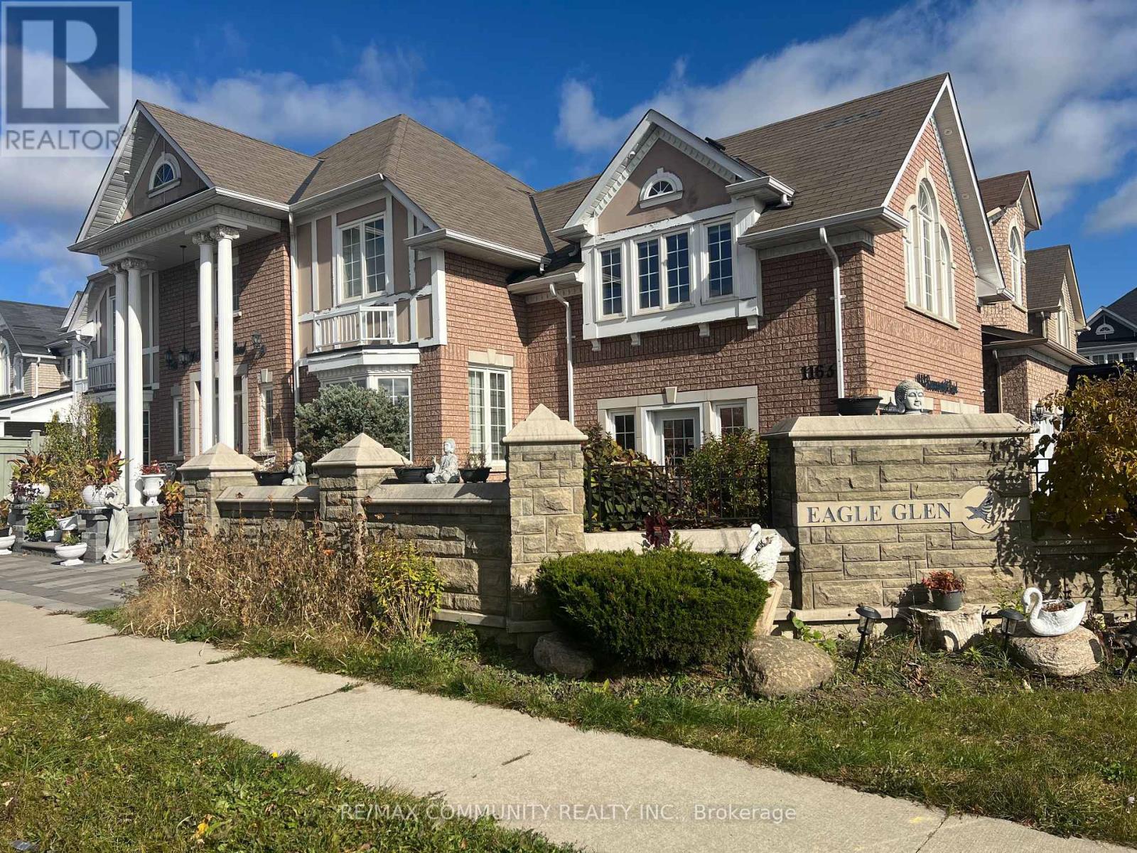 A large, well-maintained house with a sign that reads "EAGLE GLEN" in front of it.