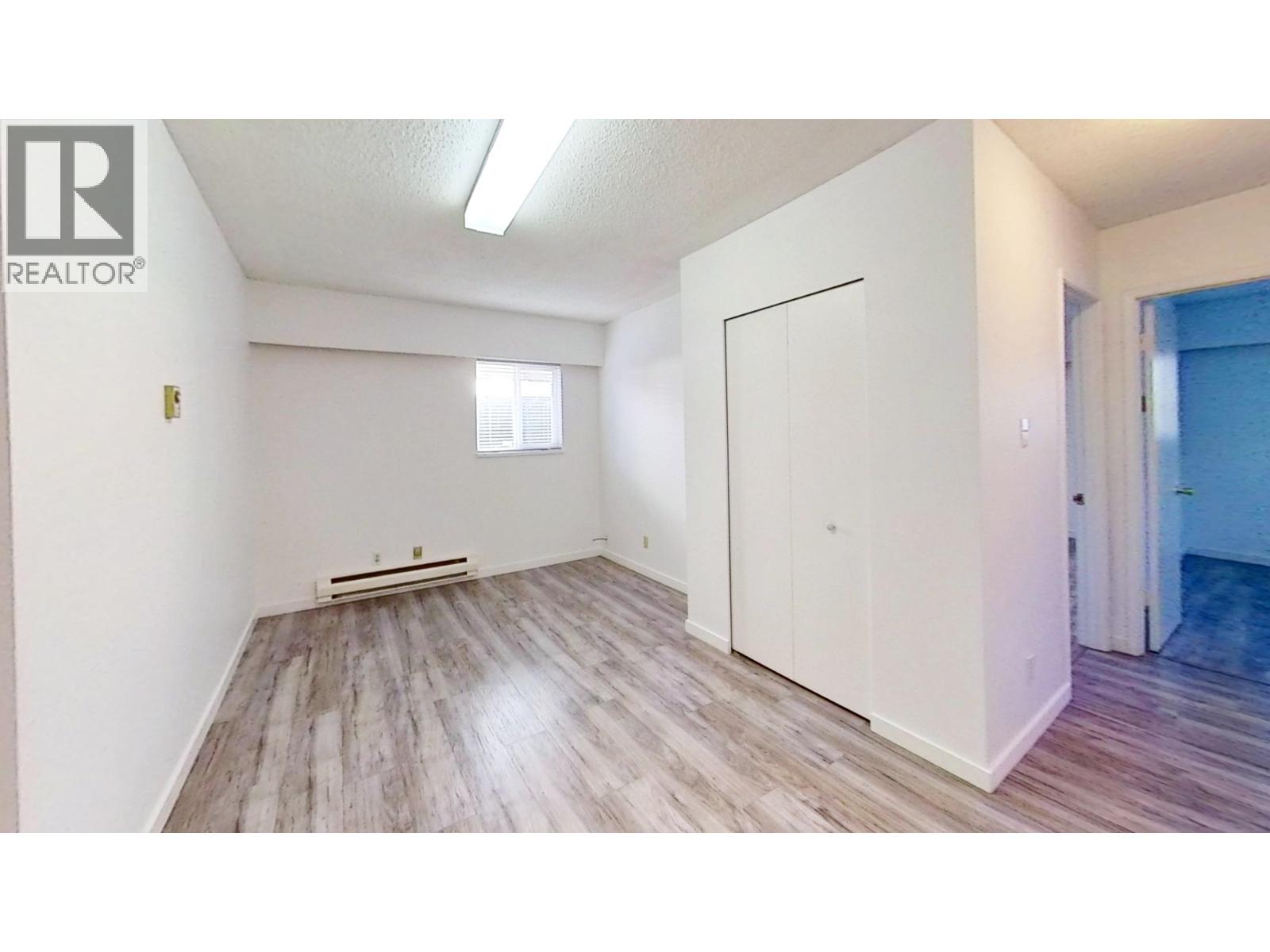 A room with a white door and a window with blinds.