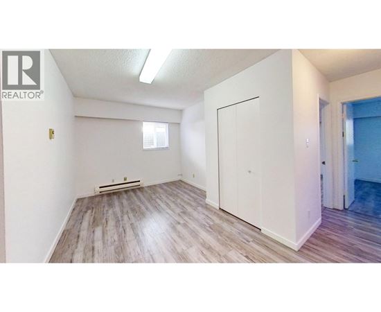 A room with a white door and a window with blinds.