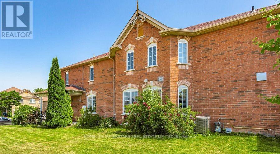 A red brick house with a green lawn in front.