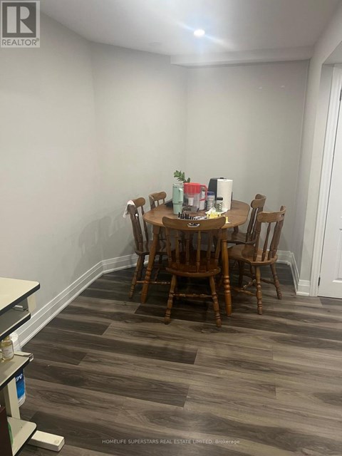 A dining room with a wooden table and chairs.
