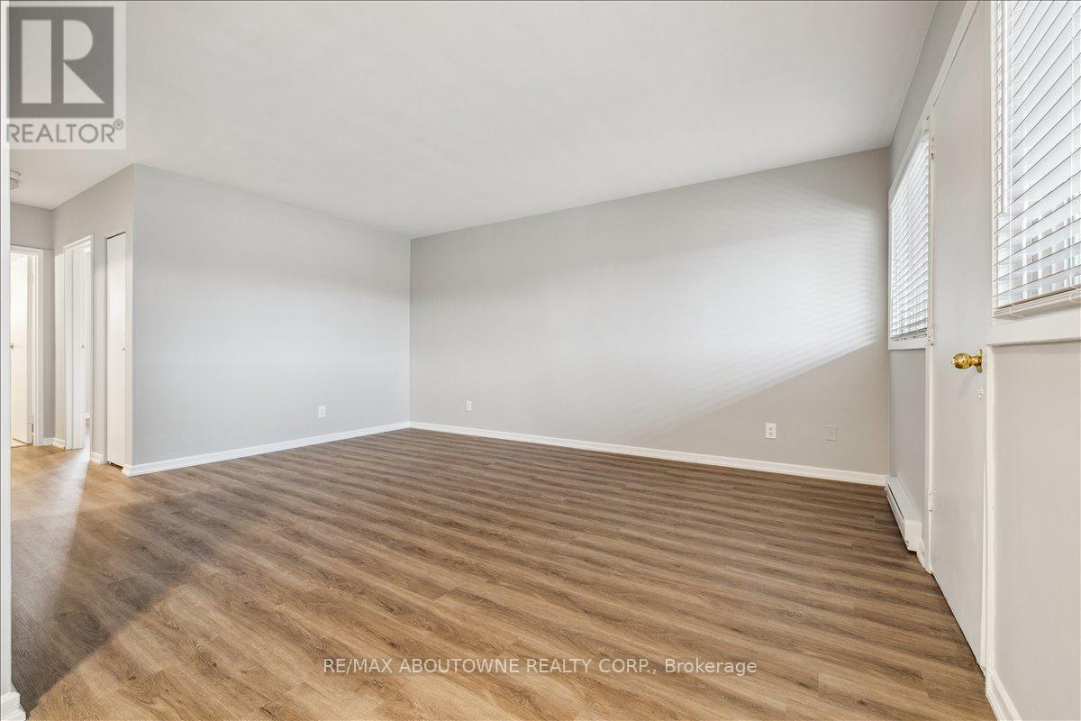 A spacious room with wooden flooring and white walls.