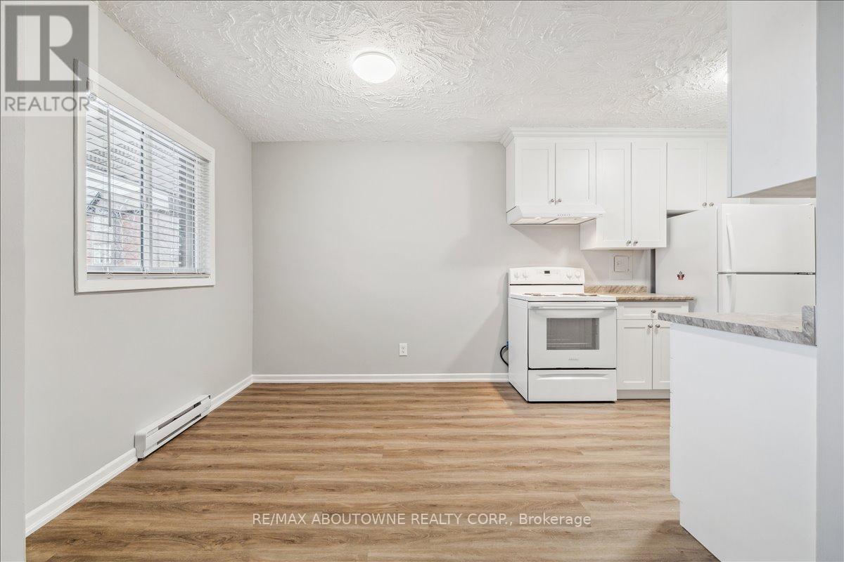 A kitchen with white cabinets and a wooden floor.