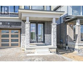 A modern house with a stone and wood exterior and a glass door.