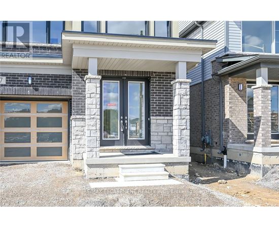 A modern house with a stone and wood exterior and a glass door.