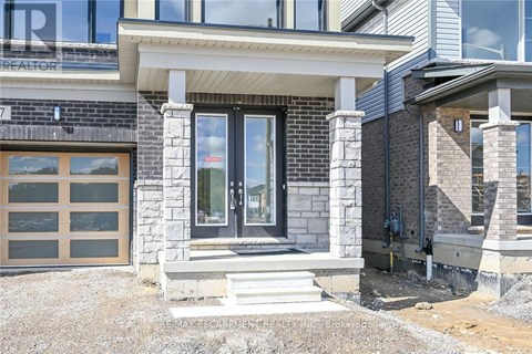 A modern house with a stone and wood exterior and a glass door.