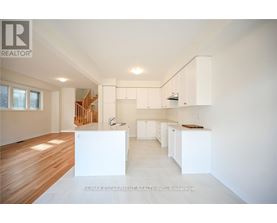 A spacious, empty room with white walls and wooden flooring.