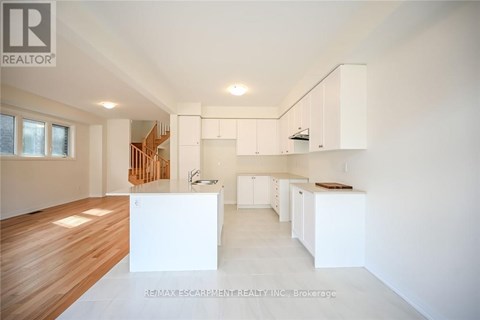 A spacious, empty room with white walls and wooden flooring.