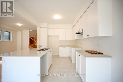 A white kitchen with a sink and cabinets.