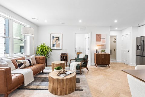 A modern living room with a brown leather couch and a wooden coffee table.