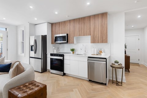 A modern kitchen with white cabinets and stainless steel appliances.