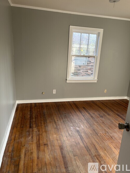 A room with wooden flooring and a window.