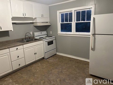 A kitchen with white cabinets and a window.