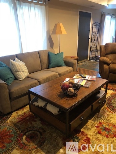 A living room with a brown sofa and a wooden coffee table.