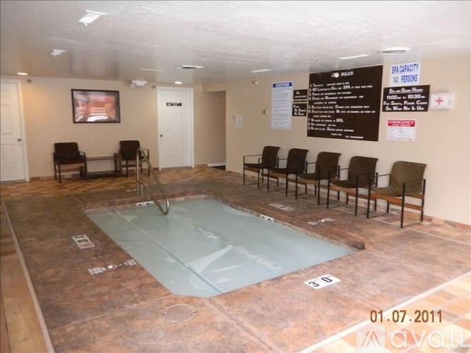 A room with a pool table and chairs.