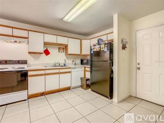 A kitchen with white cabinets and a white door.