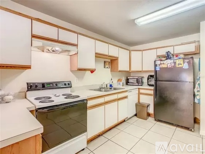 A kitchen with a stove, sink, and refrigerator.