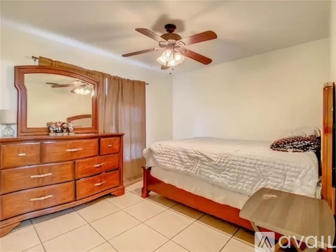 A bedroom with a bed, dresser, and mirror.