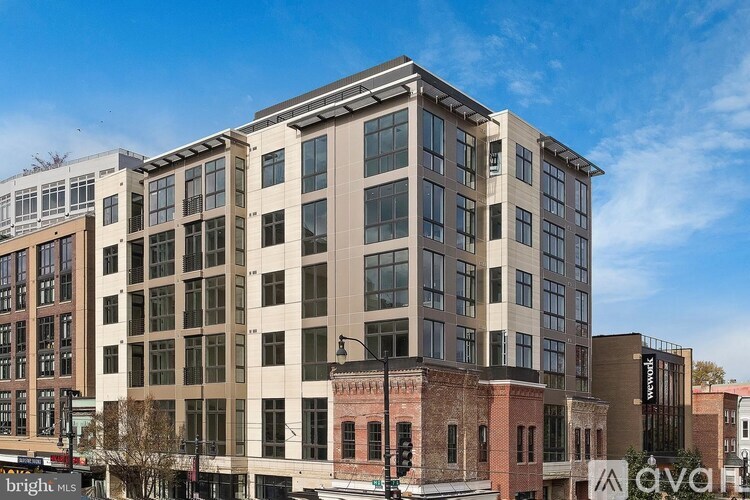 A large multi-story building with a flat roof and a mix of beige and brown exterior walls.