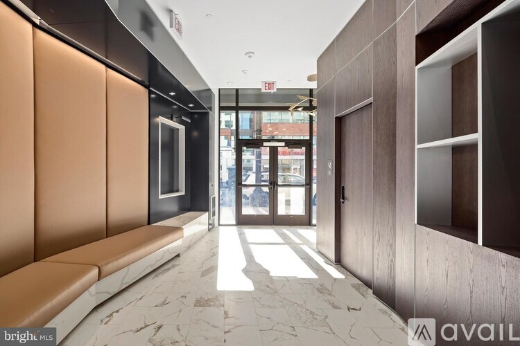 A hallway with a bench and a door with a glass window.