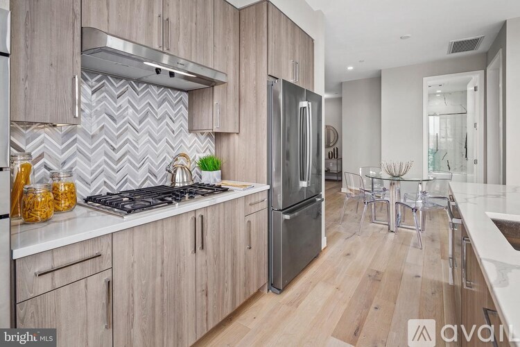 A kitchen with wooden cabinets and a stainless steel refrigerator.