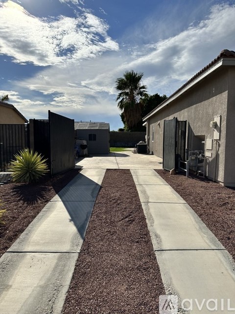 A pathway leads to a building with a gate in front.