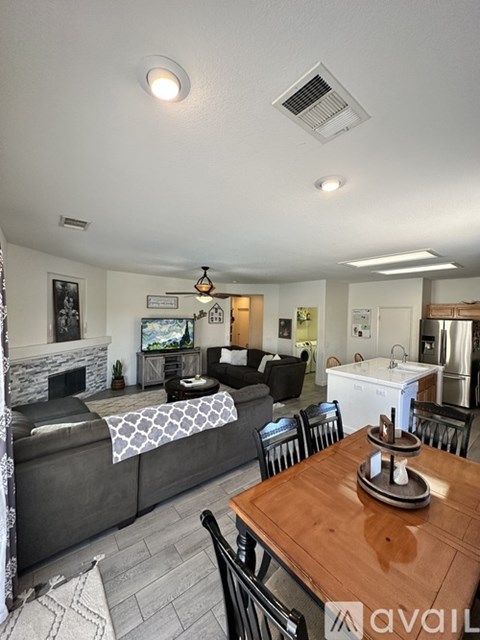 A living room with a grey couch and a wooden dining table.