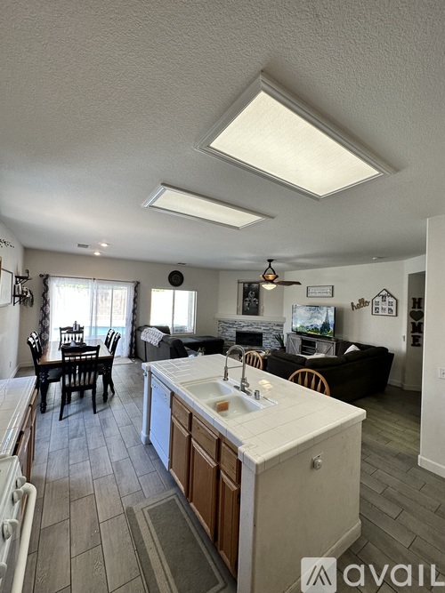 A kitchen with a white countertop and wooden cabinets.