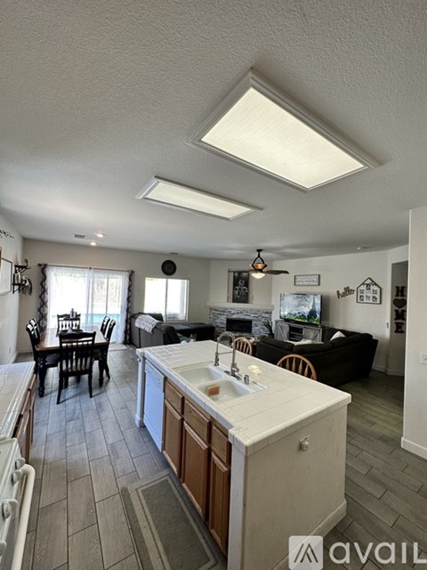 A kitchen with a white countertop and wooden cabinets.