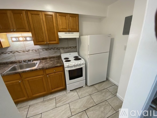 A kitchen with wooden cabinets and a white fridge.