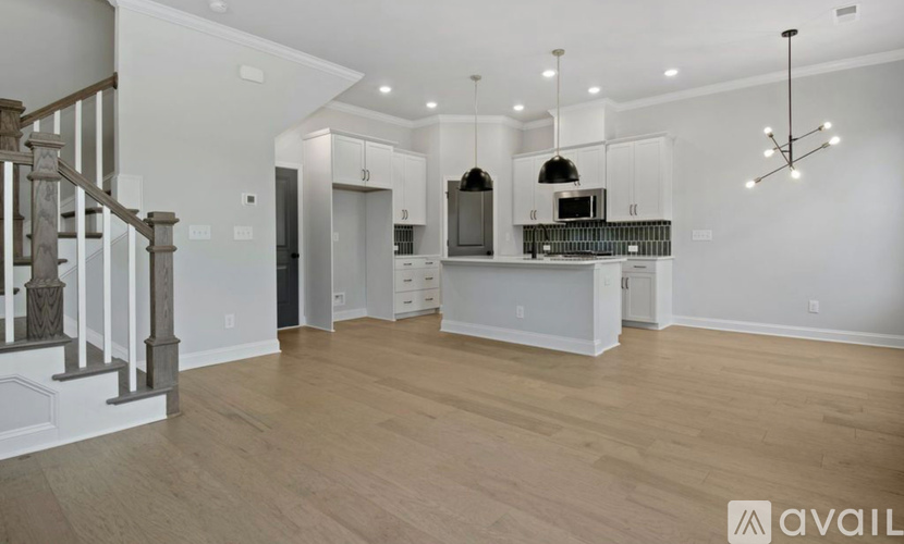 A spacious kitchen with a staircase on the left side.