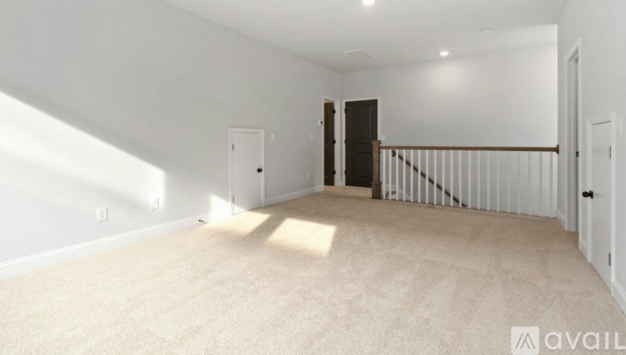 A spacious room with a staircase and a door.