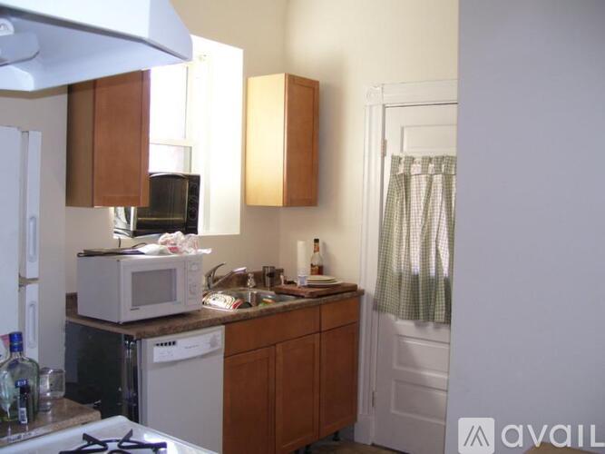 A kitchen with wooden cabinets and a white microwave.