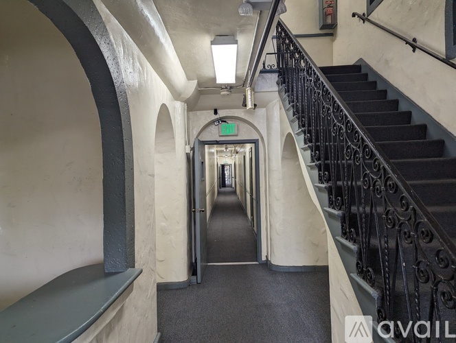A long hallway with a staircase on the right and a door at the end.