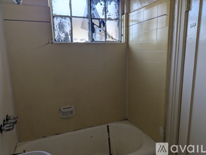 A bathroom with a toilet, sink, and window.