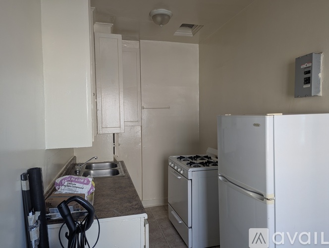 A kitchen with a white fridge, sink and cabinets.