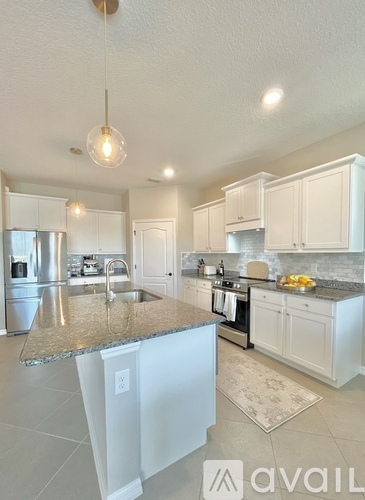 A kitchen with granite countertops and white cabinets.