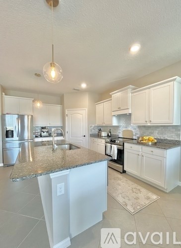 A kitchen with granite countertops and white cabinets.