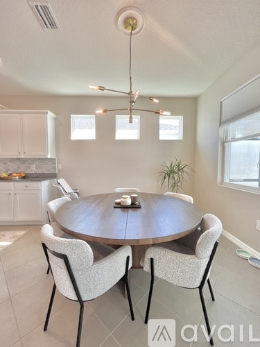 A dining room with a round table and chairs.