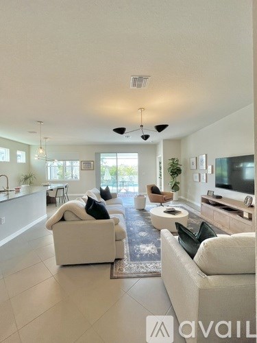 A living room with white furniture and a large window.